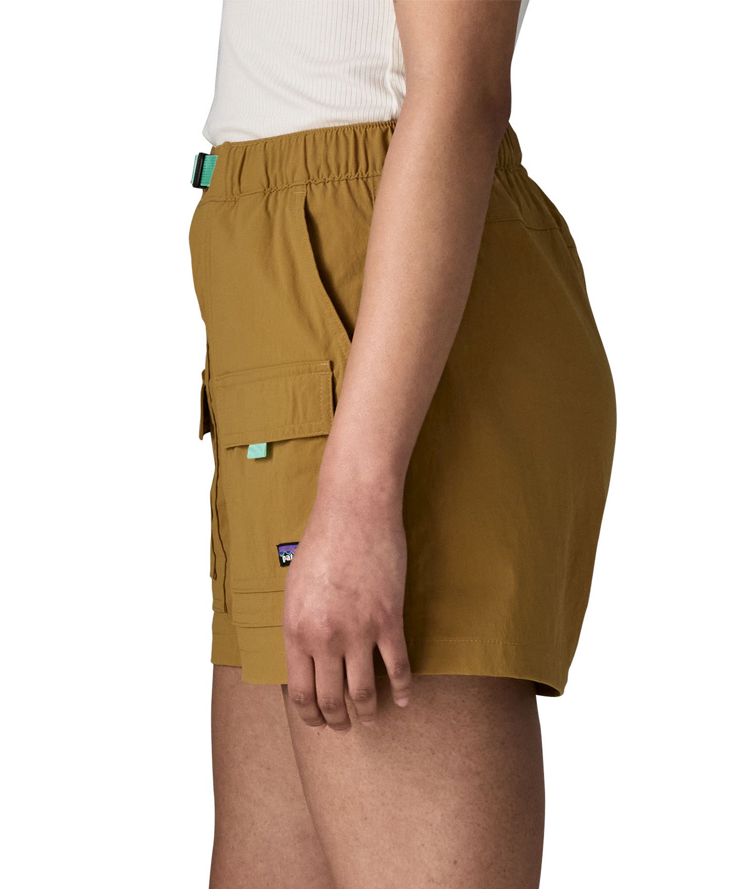 Side of woman wearing Patagonia's women's outdoor everyday shorts in brown. Shows front panel pockets.