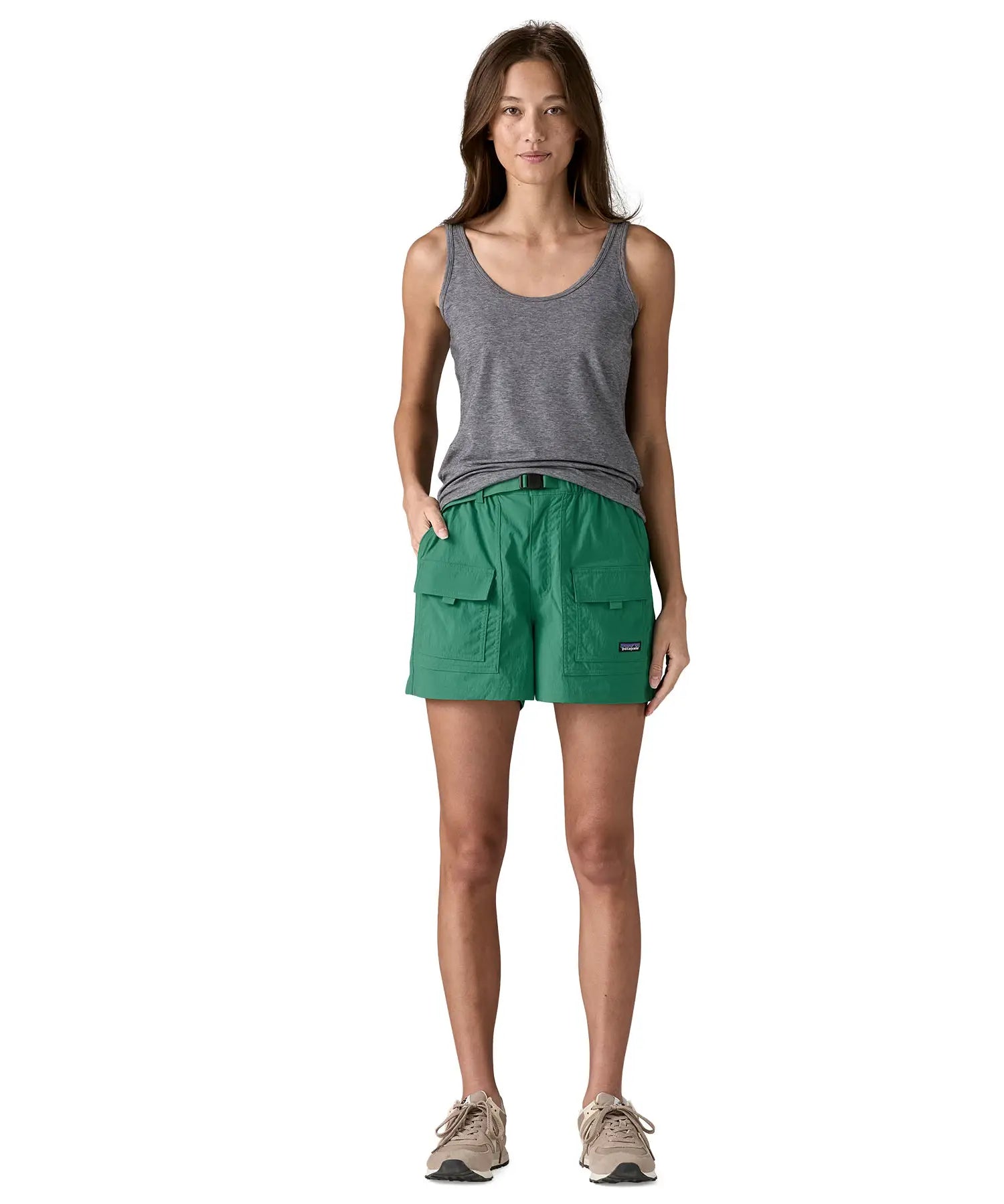 Front of Woman wearing Patagonia's women's outdoor everyday shorts in green. Shorts have a loose fit and sit above the knees
