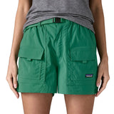 Woman wearing Patagonia's women's outdoor everyday shorts in green. Shows front pockets. Shorts have a loose fit