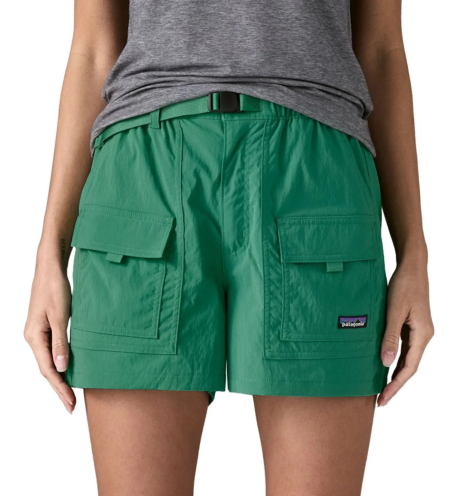 Woman wearing Patagonia's women's outdoor everyday shorts in green. Shows front pockets. Shorts have a loose fit