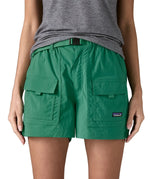Woman wearing Patagonia's women's outdoor everyday shorts in green. Shows front pockets. Shorts have a loose fit
