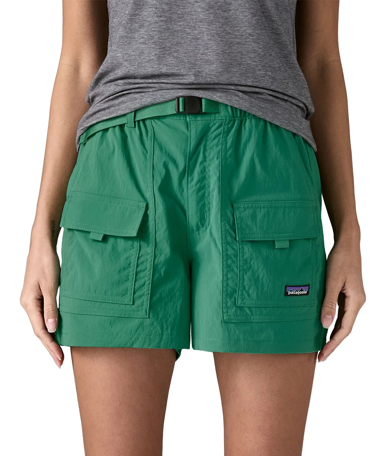 Woman wearing Patagonia's women's outdoor everyday shorts in green. Shows front pockets. Shorts have a loose fit