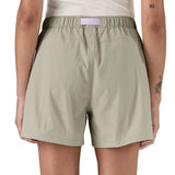 Back of woman wearing Patagonia's women's outdoor everyday shorts in light grey with light purple belt. 