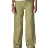 A close up of the female standing in front of a white background wearing a white t-shirt brown trainers and the Patagonia women's canvas trousers with a wide leg in light green colour showing the leg length