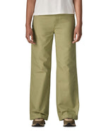 A close up of the female standing in front of a white background wearing a white t-shirt brown trainers and the Patagonia women's canvas trousers with a wide leg in light green colour showing the leg length