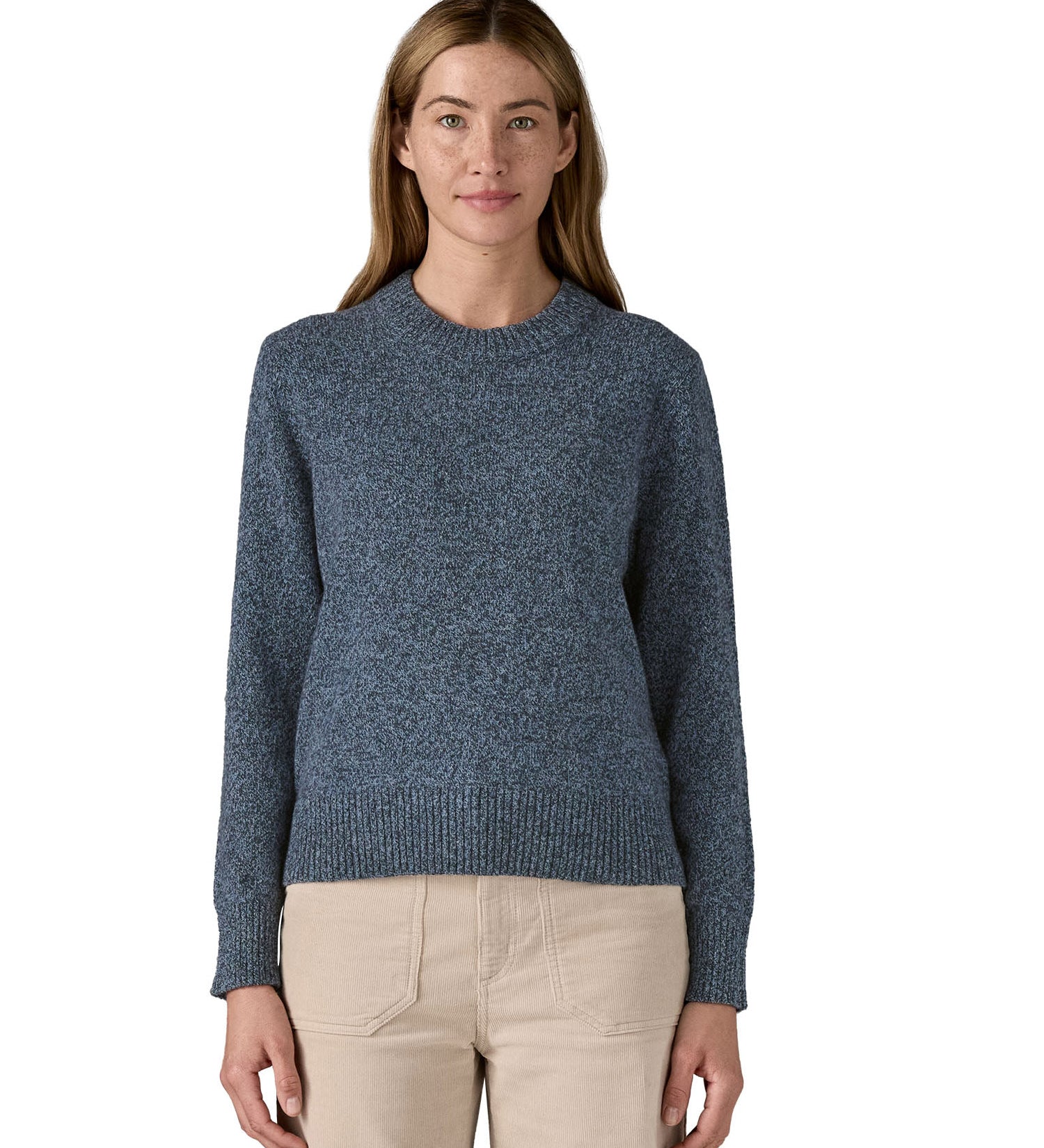 A woman wearing the Patagonia Women's Recycled Wool-Blend Crewneck Sweater. A thick knit jumper in dark blue with dappled design available at Babipur.
