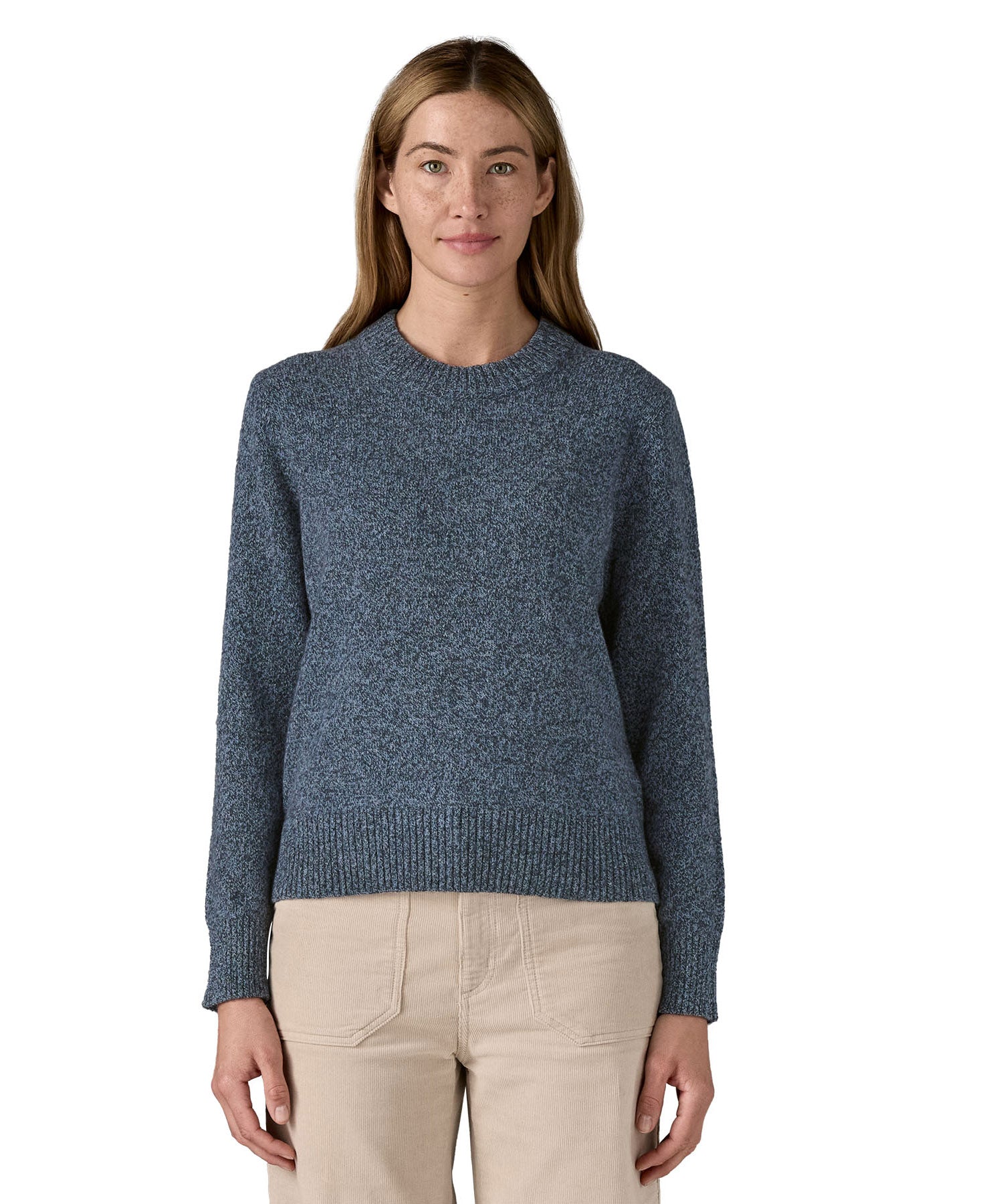A woman wearing the Patagonia Women's Recycled Wool-Blend Crewneck Sweater. A thick knit jumper in dark blue with dappled design available at Babipur.