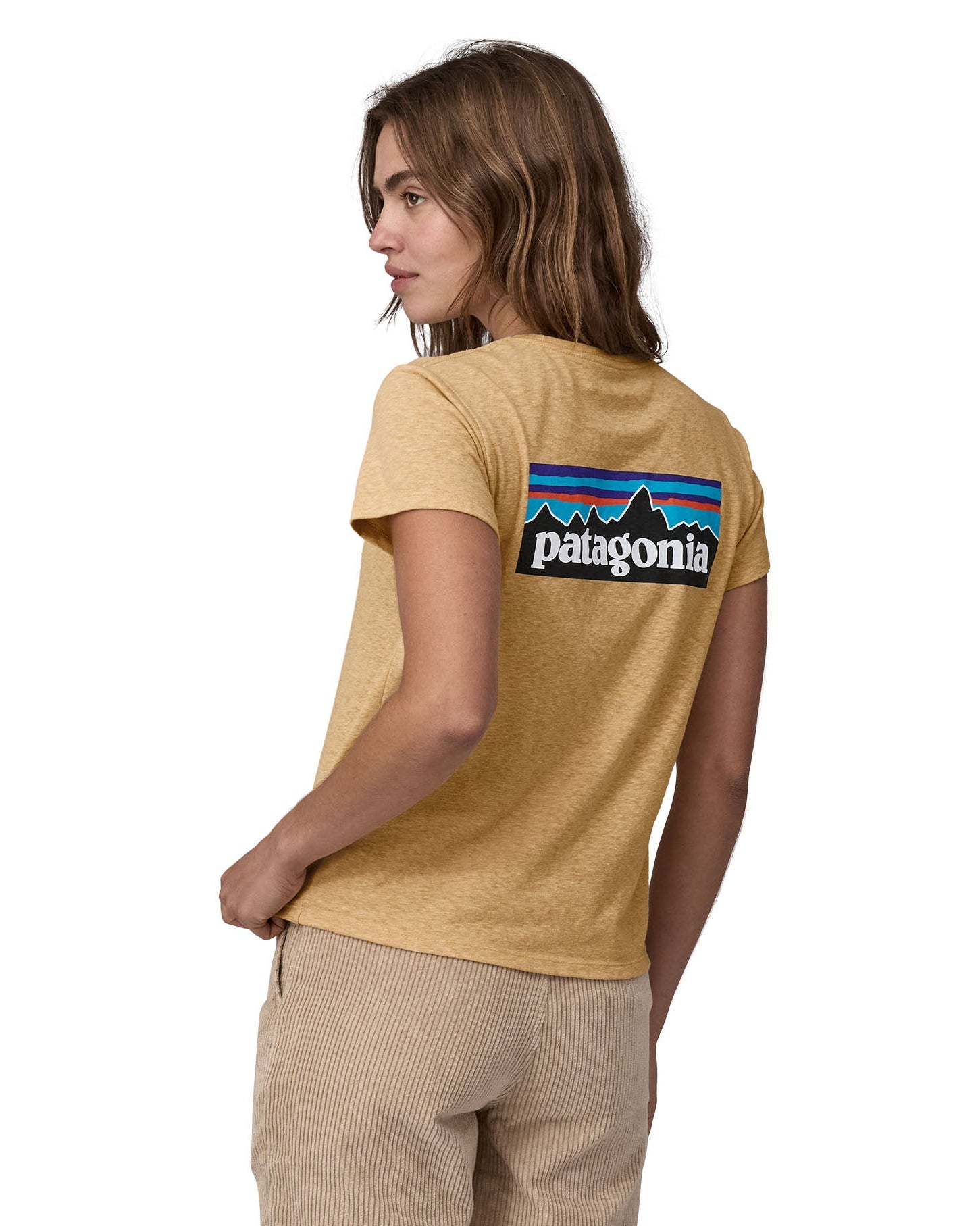 Woman wearing Patagonia's women's responibili short sleeve t-shirt in light brown with large brand patch on upper back