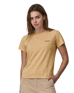 Woman wearing Patagonia's women's responibili short sleeve t-shirt in light brown with small brand text on upper chest. T-shirt has a relaxed fit
