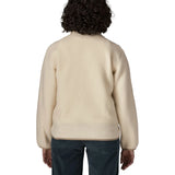 Back of woman wearing Patagonia's retro pile fleece jacket in natural cream showing a beige trim on the hem and cuff