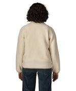 Back of woman wearing Patagonia's retro pile fleece jacket in natural cream showing a beige trim on the hem and cuff