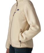 Side of woman wearing Patagonia's retro pile fleece jacket in natural cream. showing hand in the side pocket