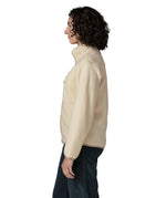 Side of woman wearing Patagonia's retro pile fleece jacket in natural cream. showing the stand up collar