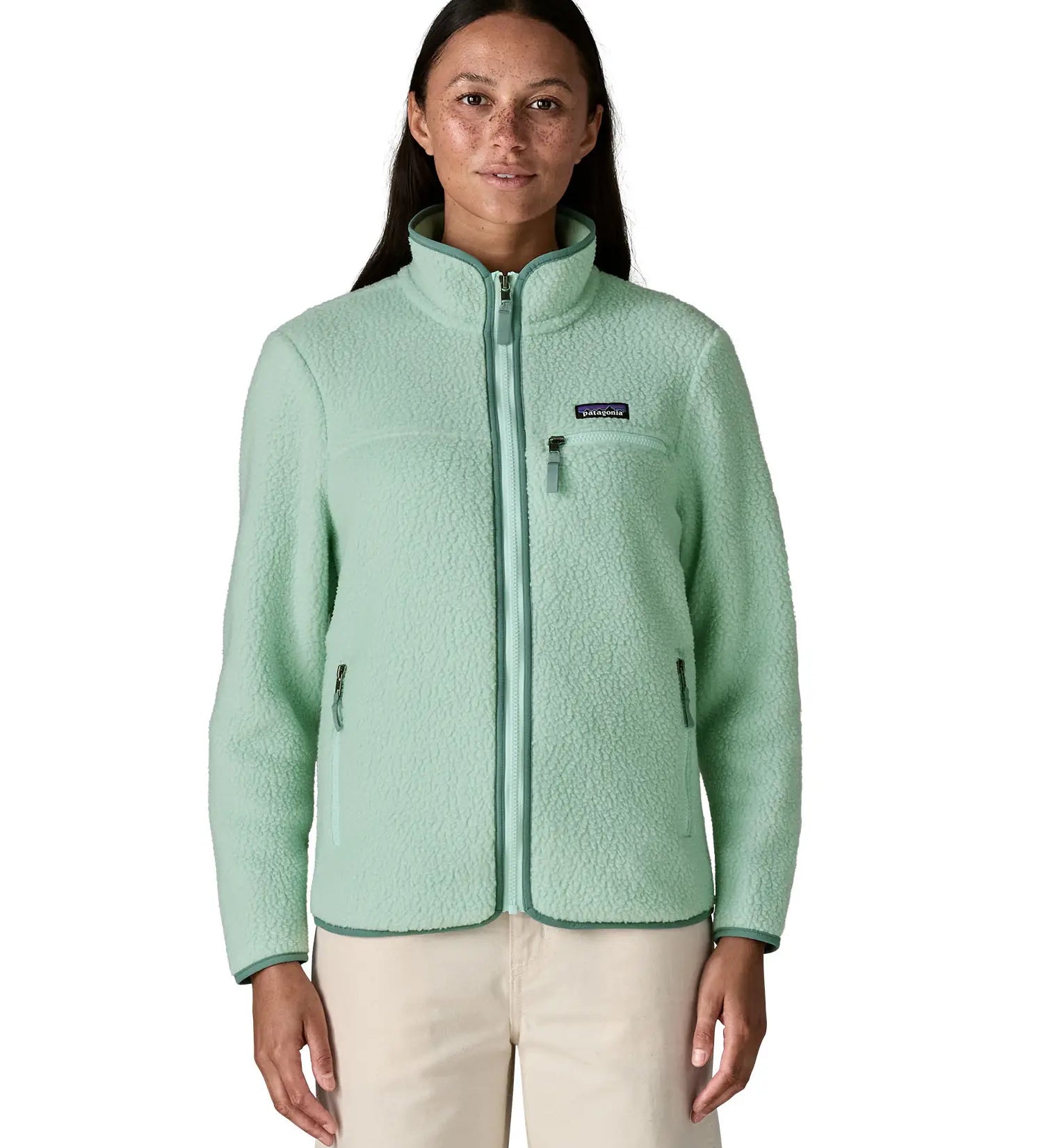 Woman wearing Patagonia women's thick fleece in light blue with a full length front zip, side pockets and a zipped chest pocket