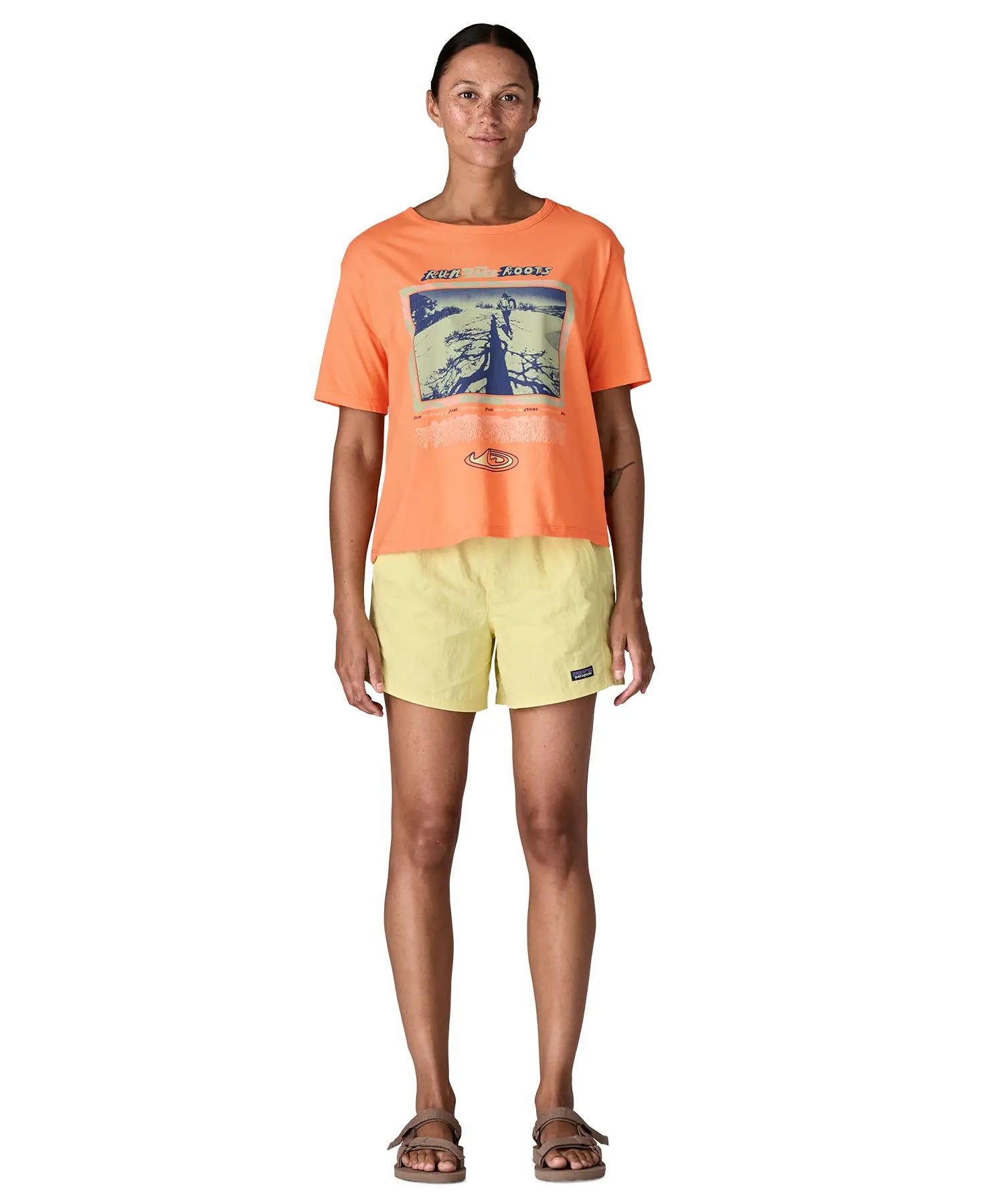 Woman Patagonia women's easy cut short sleeve t-shirt in bright orange. T-shirt has a boxy fit and sits at the hips