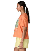 Side of woman Patagonia women's easy cut short sleeve t-shirt in bright orange. T-shirt has a boxy fit and sits at the hips