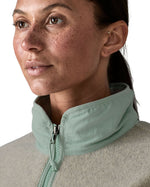 Close up of a woman wearing Patagonia women's synchilla fleece jacket in light grey blue collar trim