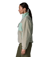 Side of woman wearing Patagonia women's synchilla fleece jacket in light grey and blue trim
