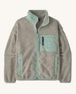 Patagonia women's synchilla fleece jacket in light grey and blue trim. With a full length front zip, side pockets and alight blue patch pocket