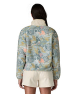 Back of woman wearing Patagonia's synchilla fleece with an abstract pastel retro design. Jacket has a relaxed fit and sits at the hips