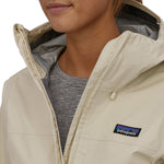 A closer look at the the chest area of the Patagonia Women's Torrentshell 3L Rain Jacket. A person is wearing the jacket and is showing the jacket partly open at the top
