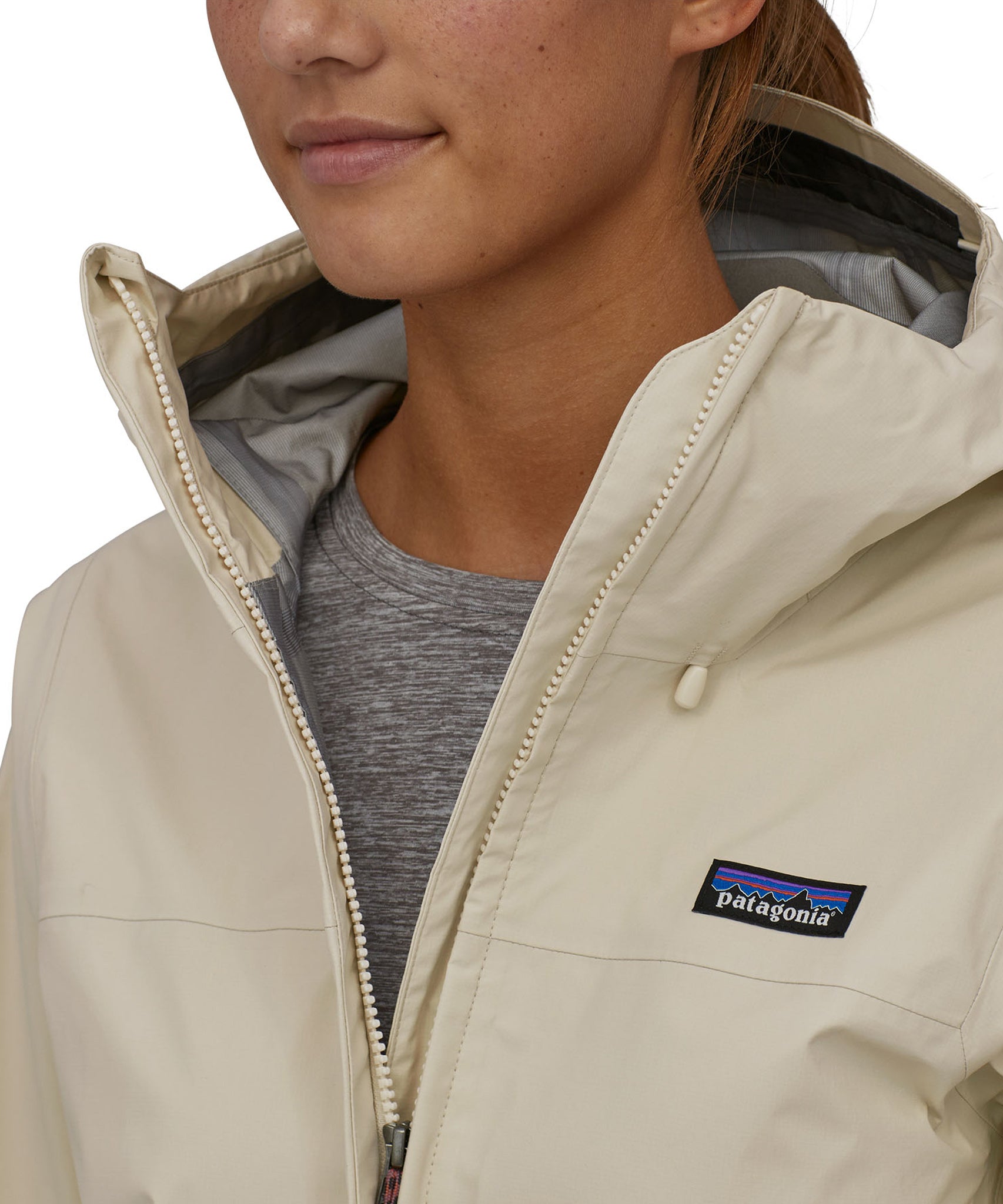 A closer look at the the chest area of the Patagonia Women's Torrentshell 3L Rain Jacket. A person is wearing the jacket and is showing the jacket partly open at the top