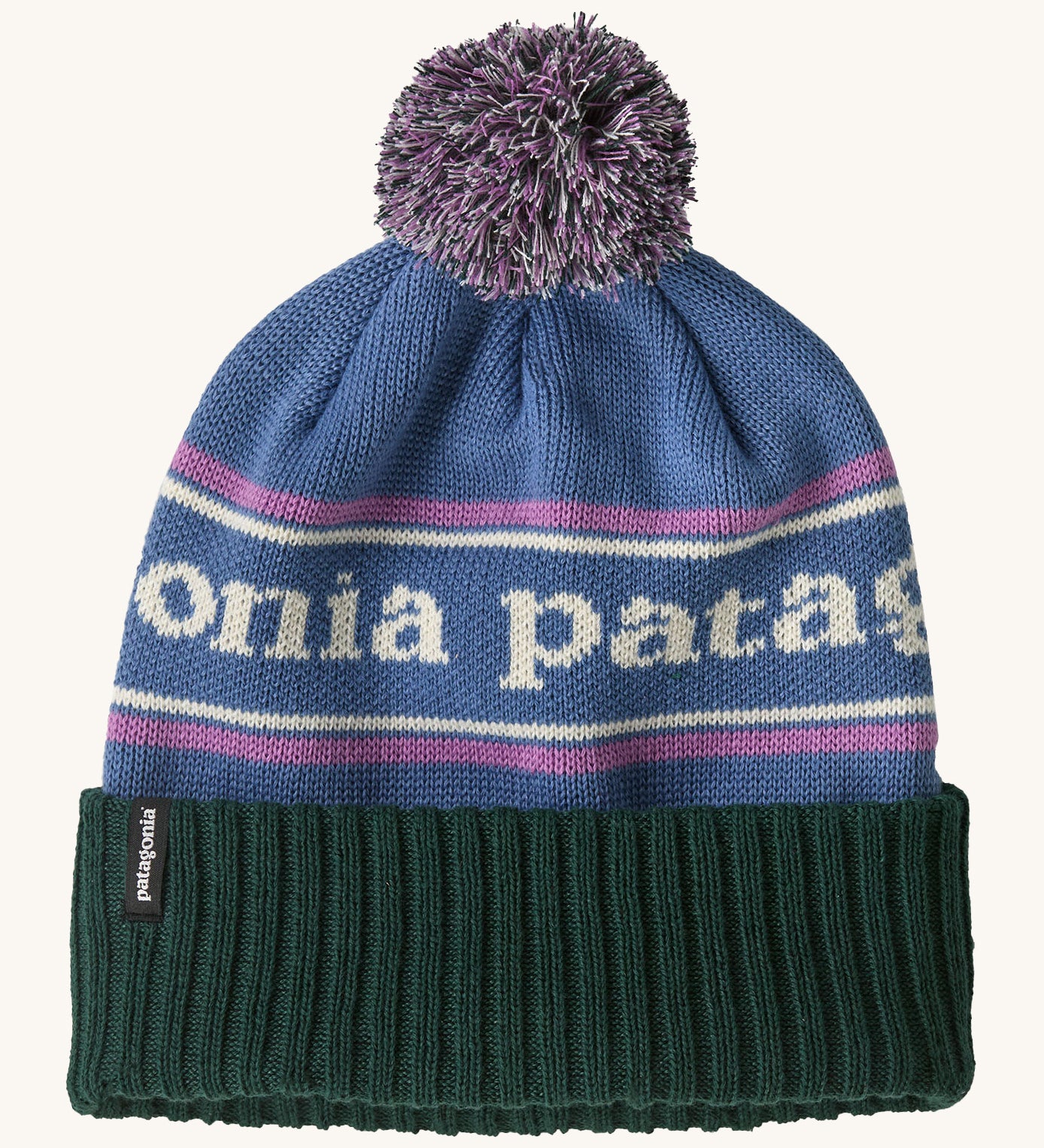 Patagonia adult powder town beanie in park stripe and barnacle blue colourway. A softknit style hat in light blue with brand name across the middle with matching blue and purple pom pom. Features a dark green turn up brim with brand patch stiched on the side