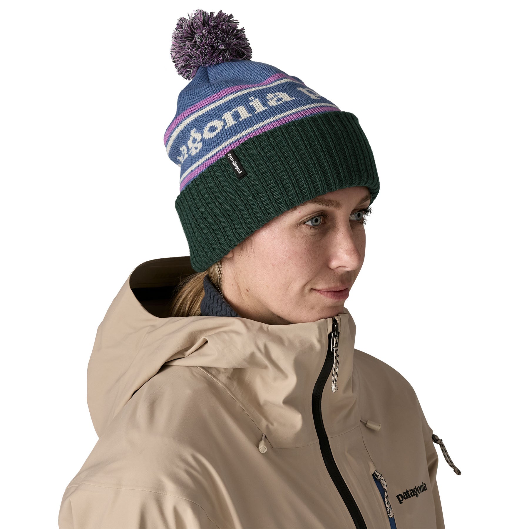 A woman wearing the Patagonia adult powder town beanie in park stripe and barnacle blue colourway available at Babipur.
