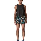 Woman wearing Patagonia quick drying women's baggies shorts in black with repeating abstract design. Shorts have loose fit
