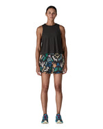 Woman wearing Patagonia quick drying women's baggies shorts in black with repeating abstract design. Shorts have loose fit