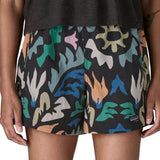 Woman wearing Patagonia quick drying women's baggies shorts in black with repeating abstract design. Shorts have a loose fit