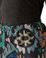 Woman wearing Patagonia quick drying women's baggies shorts in black with repeating abstract design shows elasticated waist band