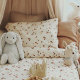 Peaches Avery Row Organic Cotton Bedding Set with toys laid out on the bed