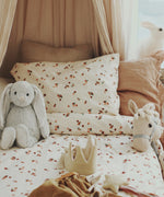 Peaches Avery Row Organic Cotton Bedding Set with toys laid out on the bed