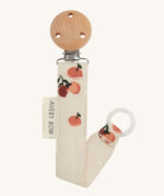 Avery Row Pacifier Holder - Peaches, showing the silicone ring and wooden clip