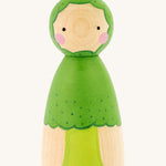 Peepul plastic-free handmade wooden broccoli peg doll toy, is a lovely bright green colour and is on a cream background. The body of the peg doll shows a painted broccoli stem and floret, and the face had two small black dot eyes, and two pink rosy cheeks.