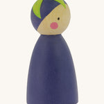 A side view of the Peepul Aubergine Peg Doll showing more of the hand painted green leaf on the top of the figure. The image is on a cream background
