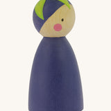 A side view of the Peepul Aubergine Peg Doll showing more of the hand painted green leaf on the top of the figure. The image is on a cream background