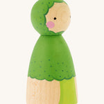 The side of the Peepul Broccoli Peg Doll, is a beautiful, hand painted peg doll with a green broccoli stem and floret body, a green painted broccoli  hood. The image is on a cream background