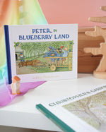 Peter in Blueberry Land children's hardback book by Elsa Beskow on shelf next to another book from the series, Christopher's Garden.