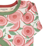 A close up of the Pigeon Organics floral bodysuit showing the popper fastener detail on the shoulder