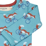 A close up of the Pigeon Organics turquoise cycling fox sheep body showing the popper fastener detail on the shoulder