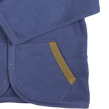 A close up of the Pigeon Organics baby jacket in velvet blue available at Babipur showing the dark green trim detail on the side pocket