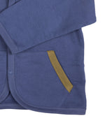 A close up of the Pigeon Organics baby jacket in velvet blue available at Babipur showing the dark green trim detail on the side pocket
