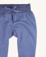 A close up of the Pigeon Organics blue sweatpants  available at Babipur showing the drawstring and elasticated waistband detail 