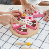 Children playing with the PlanToys wooden birthday cake set with loose candles on a table 
