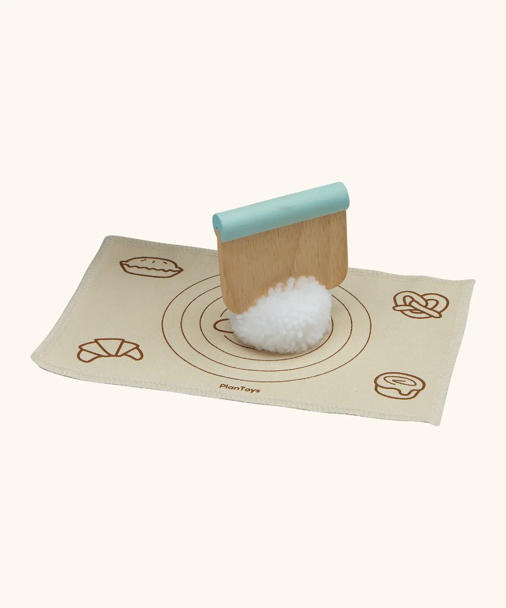 Pom Pom dough ball with a cutter on top from the PlanToys bread loaf set