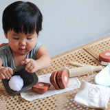 Child playing with the loose pieces from the PlanToys bread loaf play set on a table
