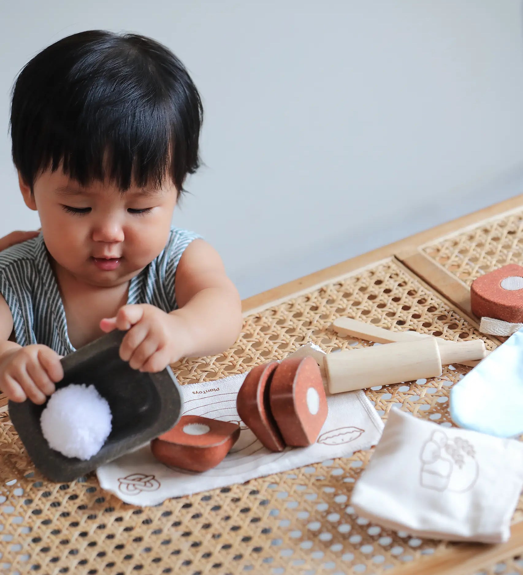 Child playing with the loose pieces from the PlanToys bread loaf play set on a table
