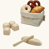 Open cotton bag filled with pretend pastries from the PlanToys bread play set 
